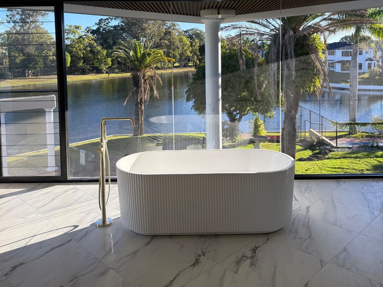 Freestanding fluted bath and gooseneck floor mixer in a renovated bathroom