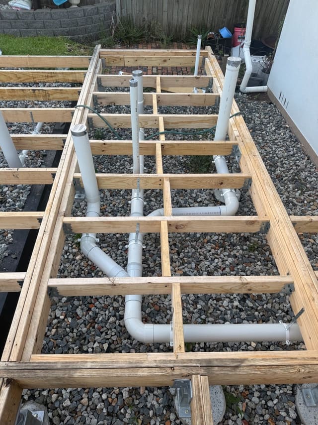 New pipework run beneath a timber floor frame before the floor goes down